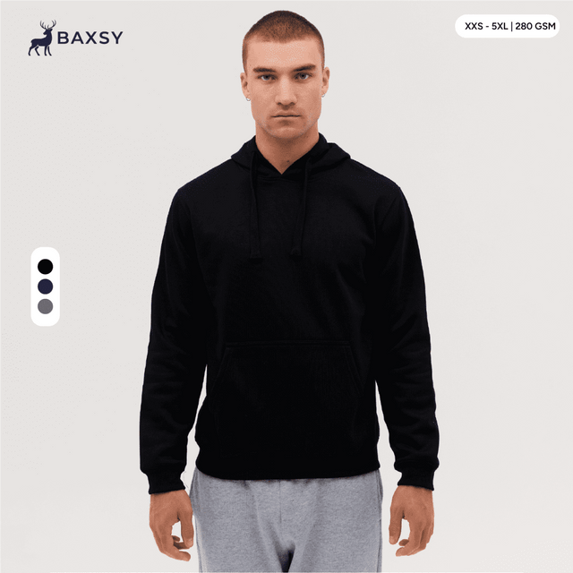 A black hoodie with a front pocket and drawstring hood, modelled by a person standing against a plain background.