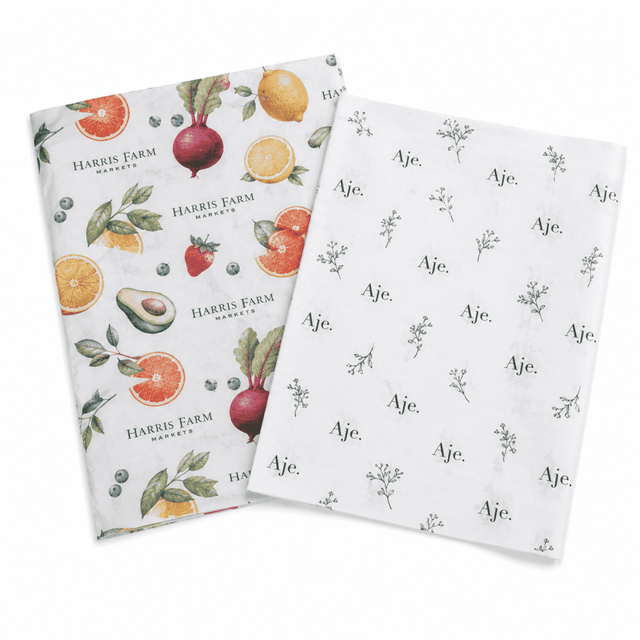 Two sheets of patterned Kraft paper, featuring fruits and floral designs in vibrant colours. One sheet has a logo.