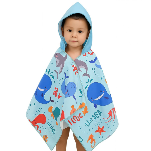 A blue microfibre hooded towel shawl featuring playful ocean-themed designs, worn by a young child.