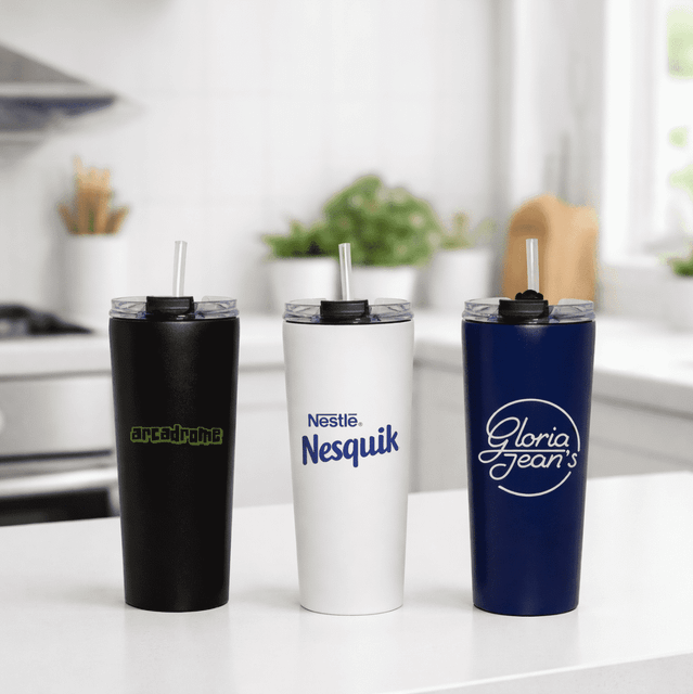 Three vacuum tumblers in black, white, and navy blue, each with a straw and a logo on the front.