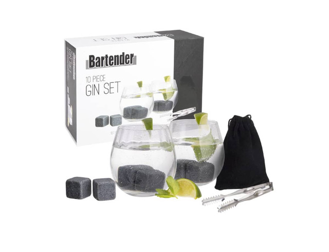 A gin set with four glass tumblers, grey cooling stones, a tong, and a black storage pouch, all in a box.