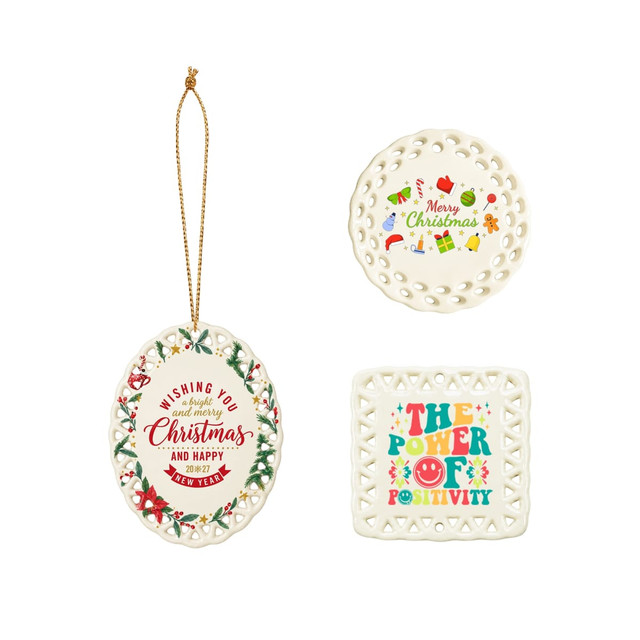 A ceramic ornament in white featuring festive designs, including Christmas themes and a positive message. It has a hanging loop.