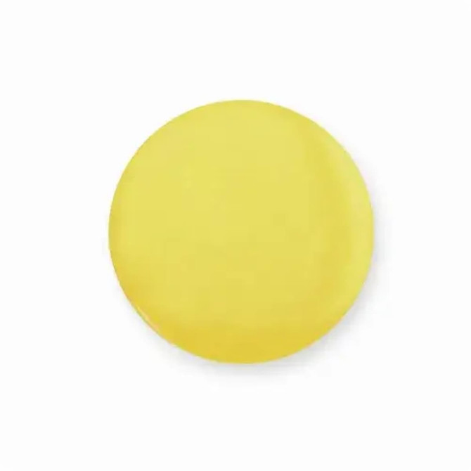 A round, yellow button badge with a shiny finish and a plain surface.