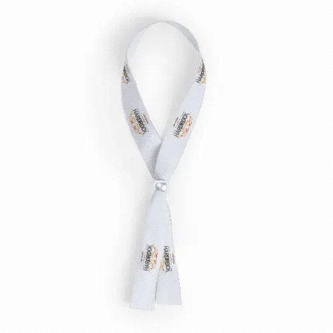 A white wristband featuring a logo, designed for events and exhibitions, with a looped fastening.