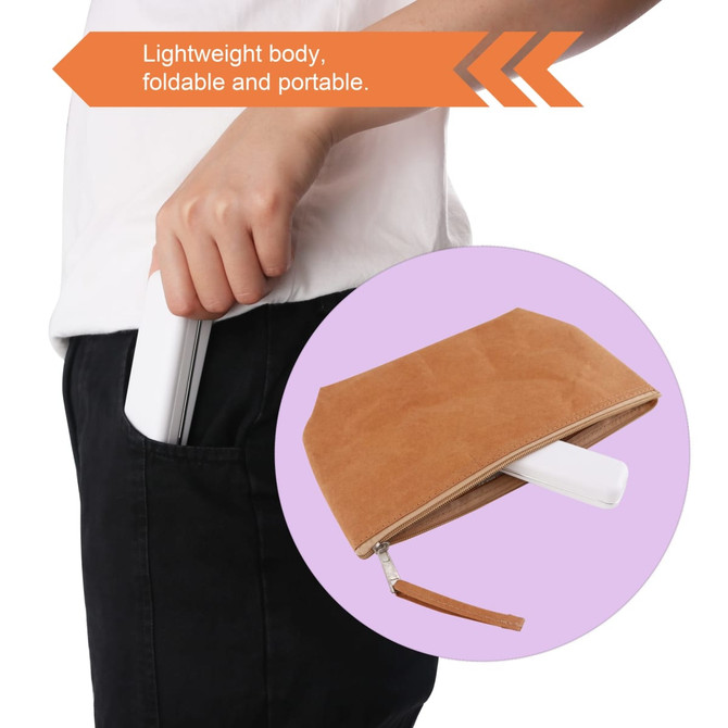 A portable UV sterilizer with a lightweight white body, being held in a pocket, alongside a brown pouch.