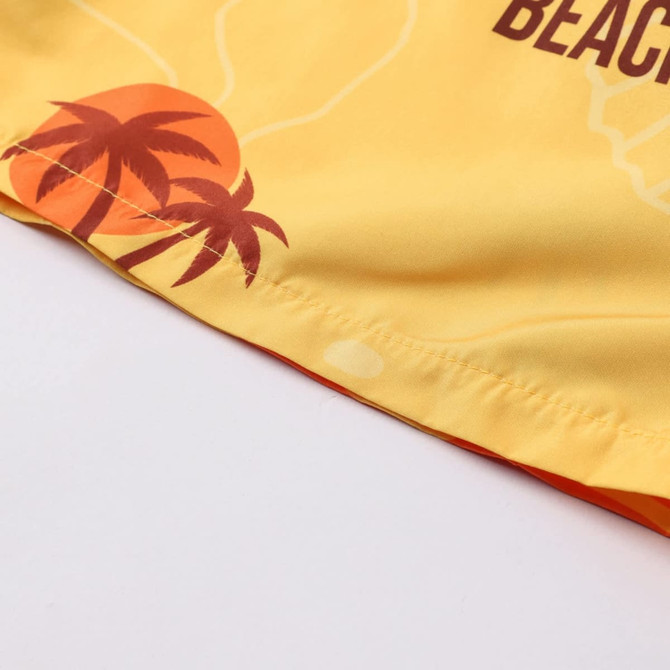 Men's polyester board shorts in yellow with a palm tree and sunset design, featuring a logo.