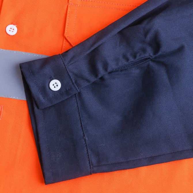 A close-up of a unisex cotton hi-vis long sleeve shirt, featuring orange and navy colours with a reflective strip.