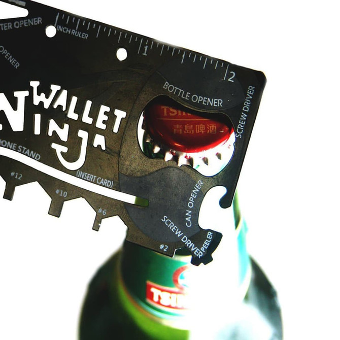 A card-sized multi-tool in black featuring a bottle opener, screw driver, and ruler, designed for compact convenience.