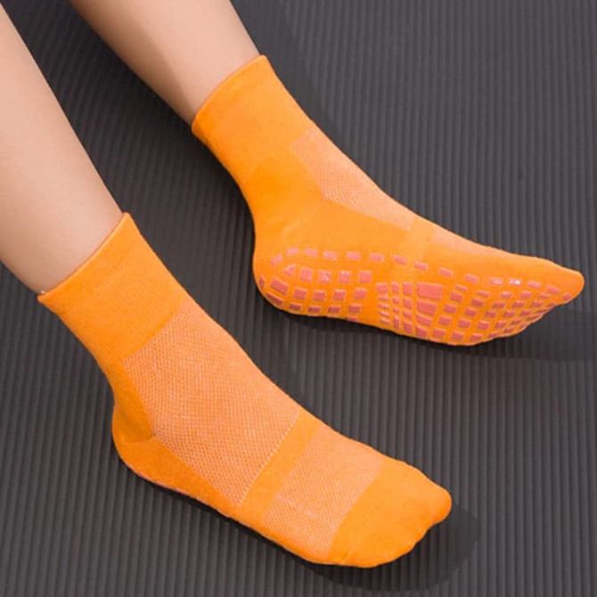 Orange gripper socks featuring a textured sole and mesh design, suitable for kids' footwear.