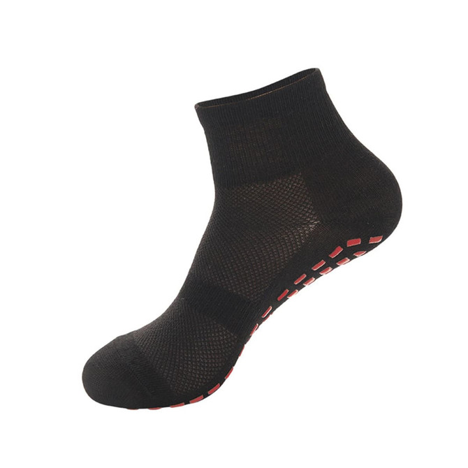 A pair of black children's gripper socks with a textured design and red non-slip grip on the sole.