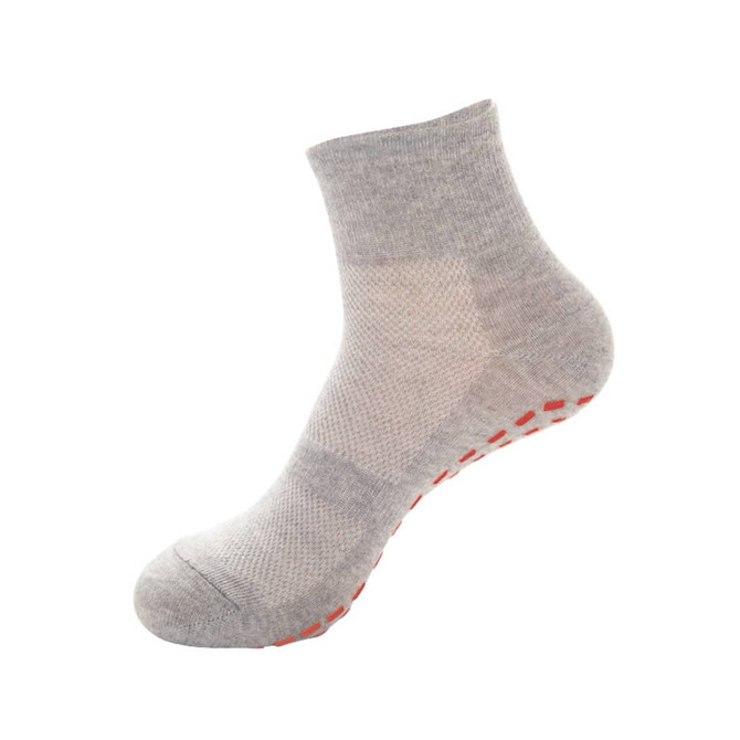 Grey gripper sock with a textured design and orange grip dots on the sole, featuring a logo.