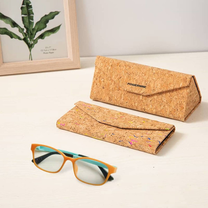 A foldable cork glasses case in natural tones, with a pair of glasses displayed beside it, featuring a logo.