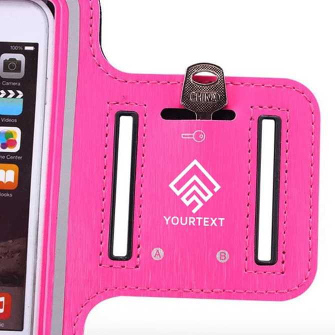 A pink cell phone arm band with a slot for a phone and a logo area, designed for secure storage and access.