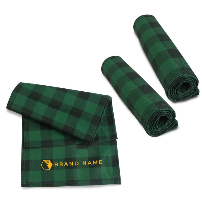 A green and black checkered table runner with two rolled matching pieces, featuring a logo on one side.