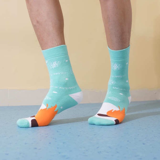 A pair of turquoise socks featuring a snow and flame pattern, with a logo on the side.