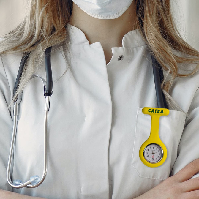 A yellow silicone nurse watch attached to a white lab coat, alongside a stethoscope.
