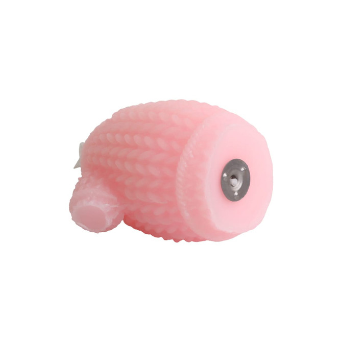 A pink sweater-shaped candle with a textured design and a metal base.