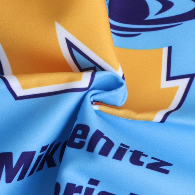 A golf towel featuring a blend of blue and yellow colours with a logo. The fabric has a smooth, soft texture.