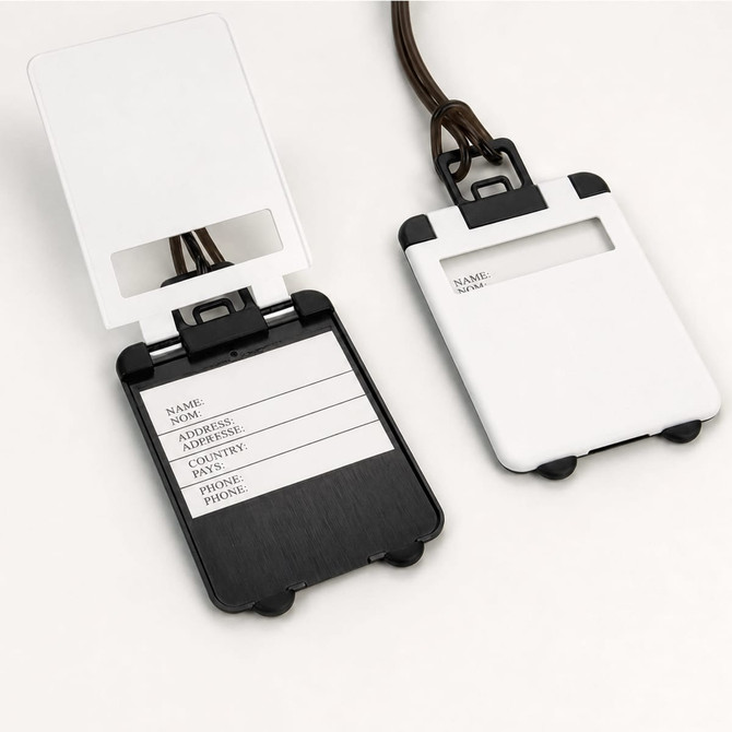 A set of ABS luggage tags in white and black, featuring a clear window and space for personal details.