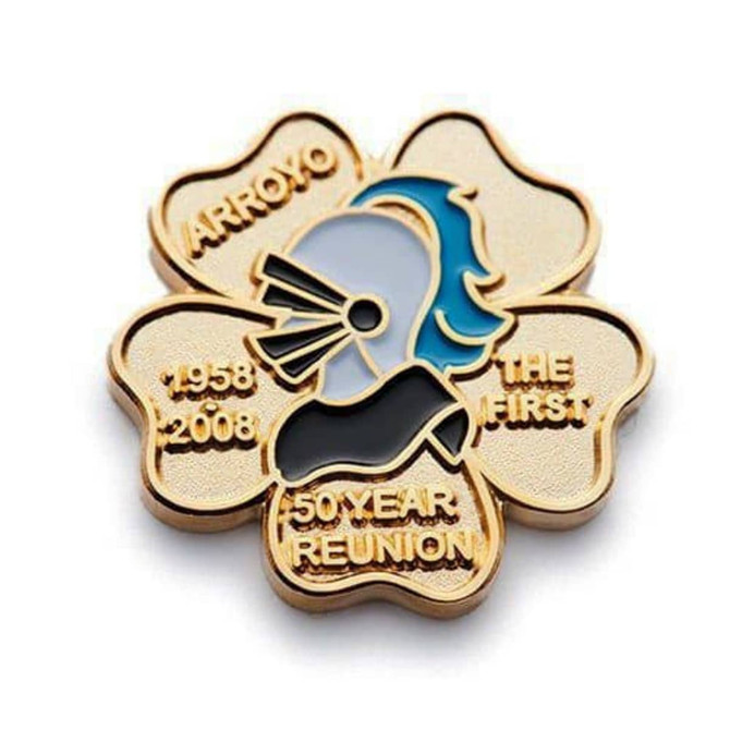A gold embossed soft enamel pin featuring a stylised profile, set in a flower shape with inscriptions.