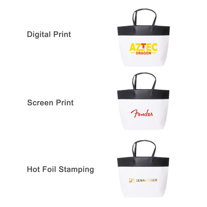 A medium black and white boutique paper bag featuring a black top and white body, with three different printed designs.