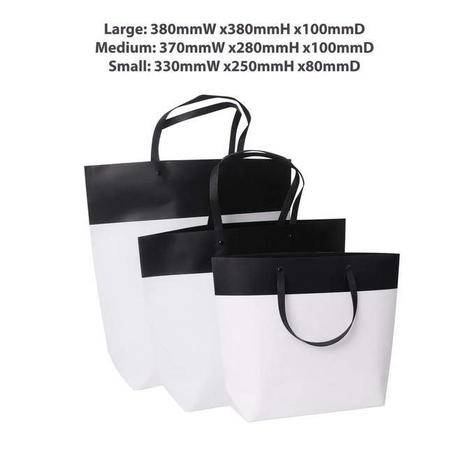 Three paper bags in black and white, featuring a large, medium, and small size with handles, and a logo on the large bag.