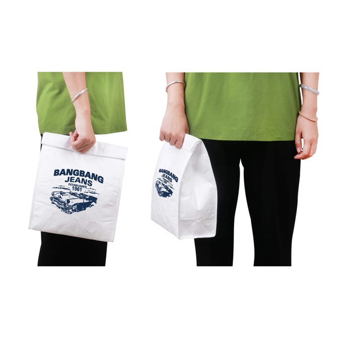 A white Tyvek cooler lunch bag held by a person, featuring a logo and a rectangular design.