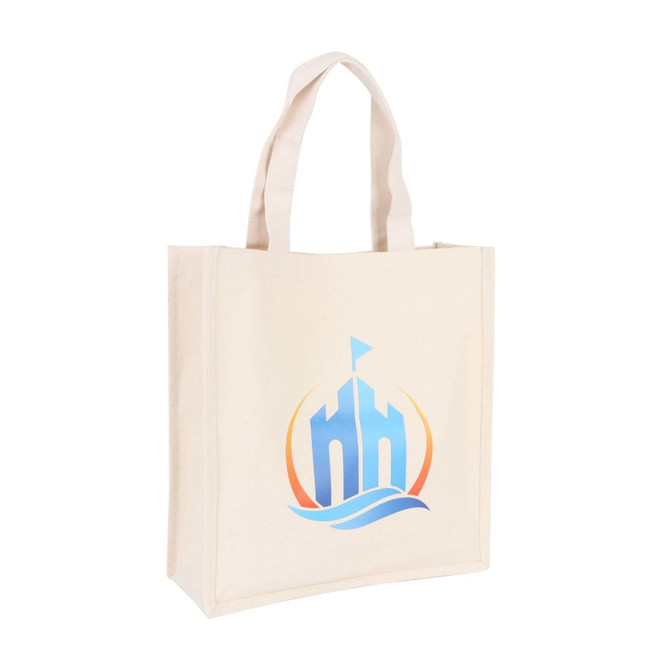 A cream-coloured cotton tote bag with a logo featuring a stylised building and wave design.