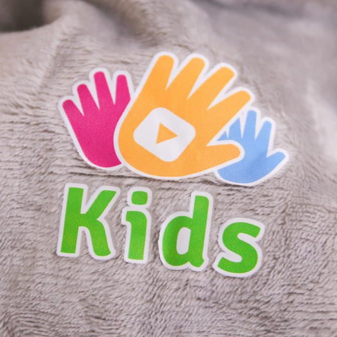 A plush grey hand puppet featuring a rhinoceros design, with colourful hand shapes and a logo.