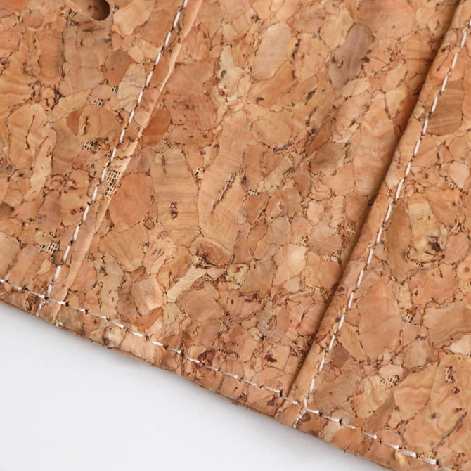 A textured cork surface features natural tones and stitched detailing, representing an RFID cork passport holder.