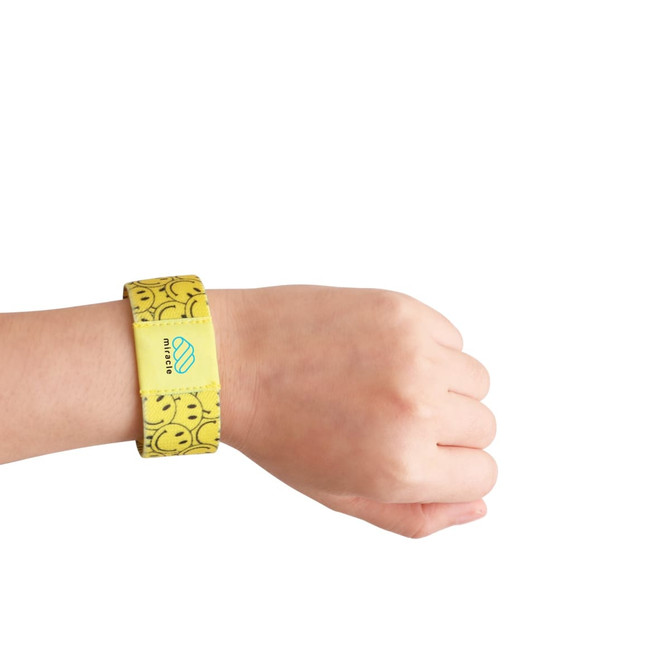 A yellow stretchy wristband featuring a smiley face design and a logo on the side, worn on a wrist.