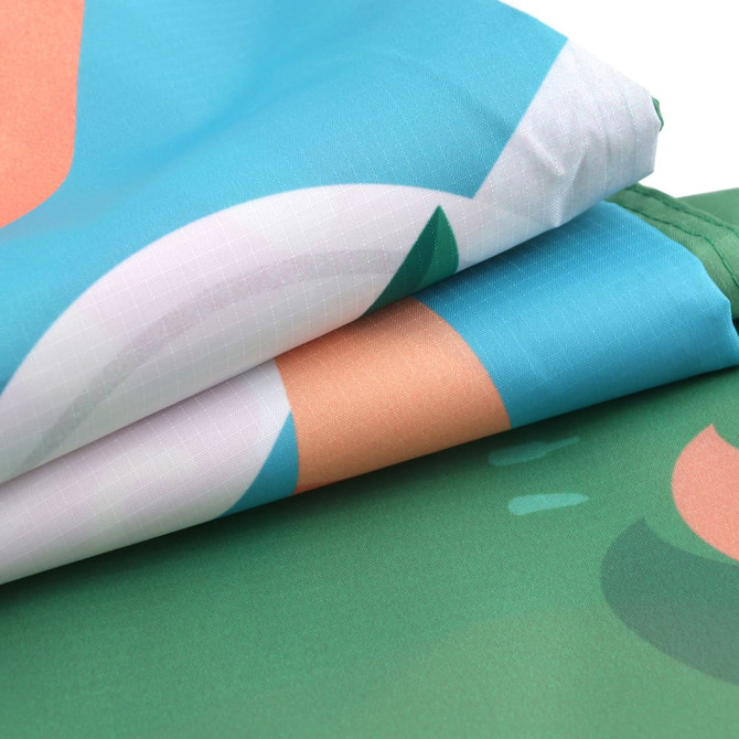 A folded outdoor blanket featuring a vibrant design with blue, green, and peach colours, along with a logo.