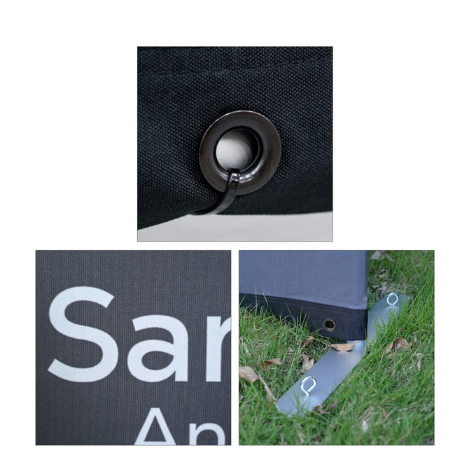 Close-up of a black barrier with a metal eyelet, logo, and a stabilising foot on grass.