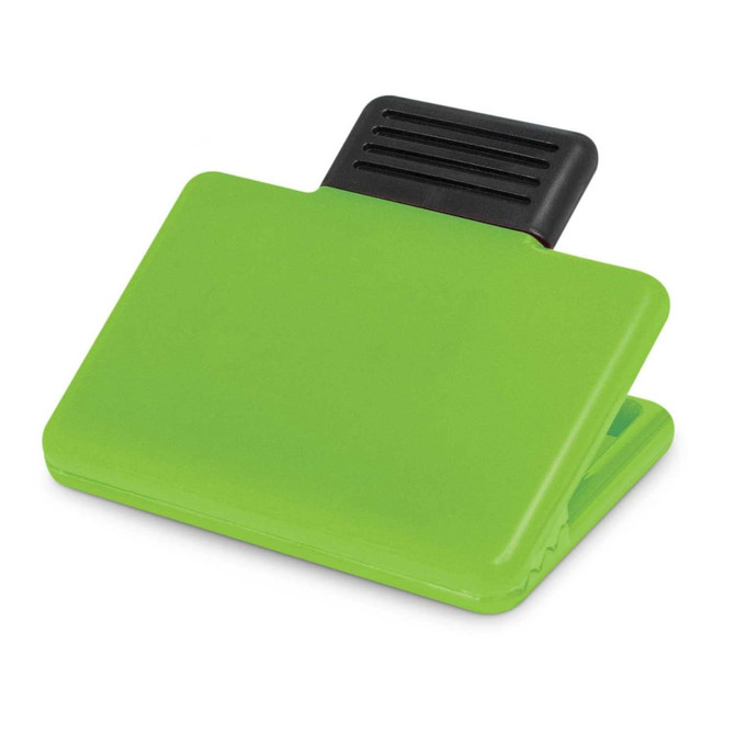 A green magnetic clip with a black grip section, designed for securing papers or notes.
