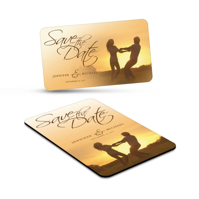 A rectangular fridge magnet featuring a sunset image with a couple dancing, including a logo or branding.