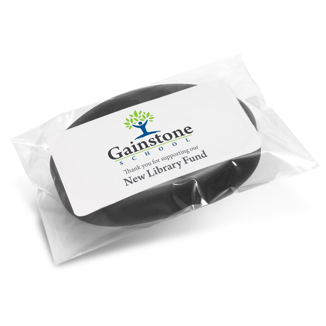 A black silicone wristband packaged in a clear plastic wrapper, featuring a logo.