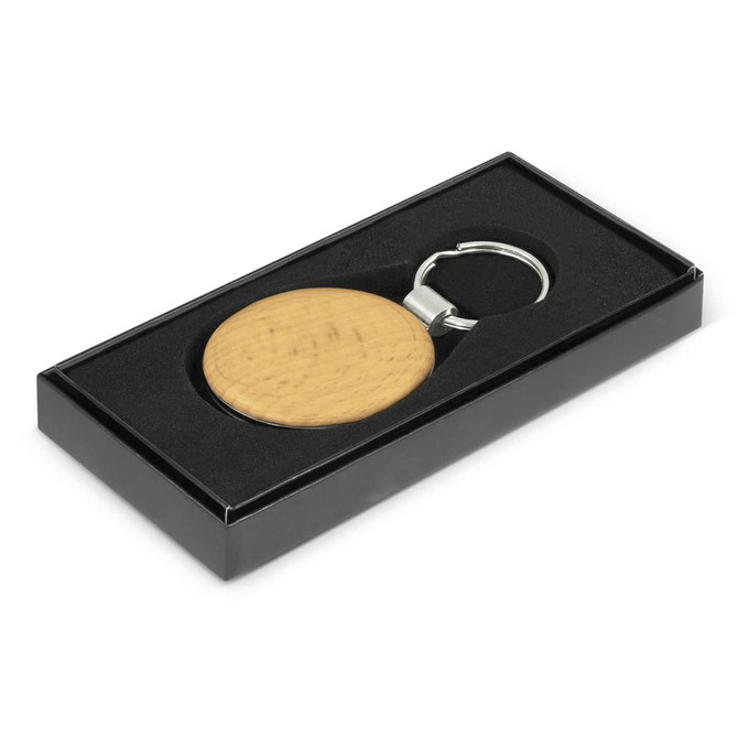 A round key ring in a wooden finish, presented in a black gift box with a silver keychain attachment.