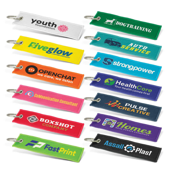 A collection of woven key rings in various colours, each with a logo or branding.