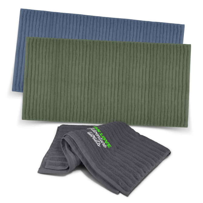 Three luxurious towels in blue, green, and grey, featuring textured patterns and a logo.
