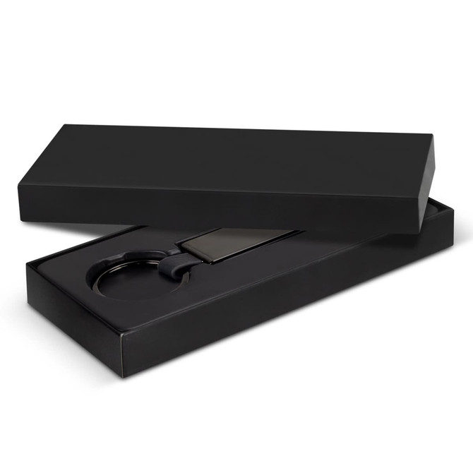 A black gift box containing a black key ring and a rectangular tag. The box is sleek and presents an elegant design.
