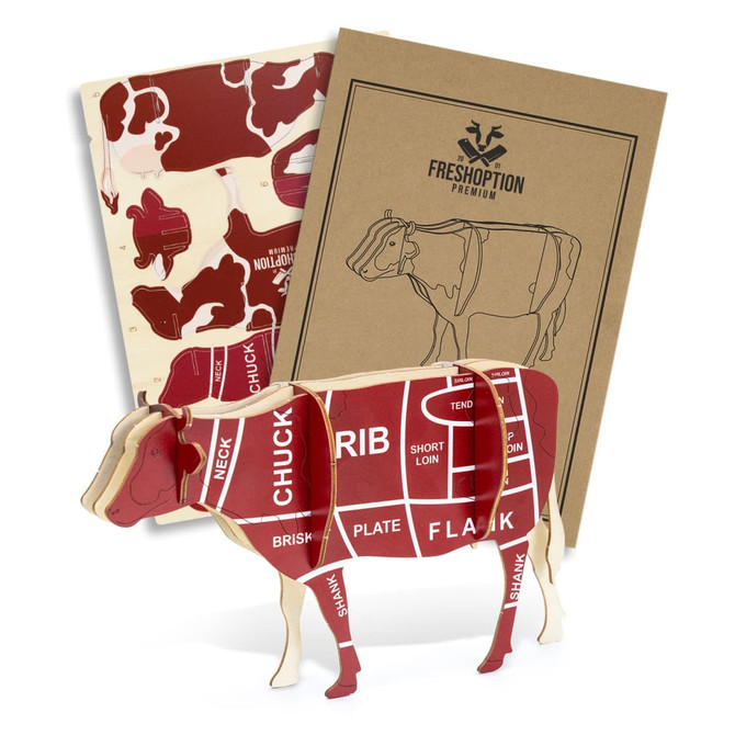 A wooden model of a cow in red and cream, featuring anatomical cuts, accompanied by two instructional booklets.