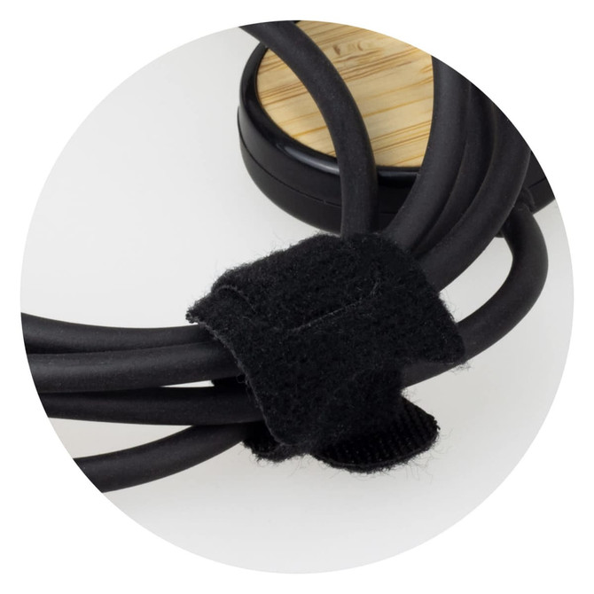 A black charging cable with a fabric tie, coiled neatly around a bamboo base, featuring a logo.