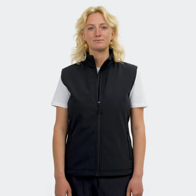 A woman wearing a black, sleeveless vest with a zip front and a logo on the left side.