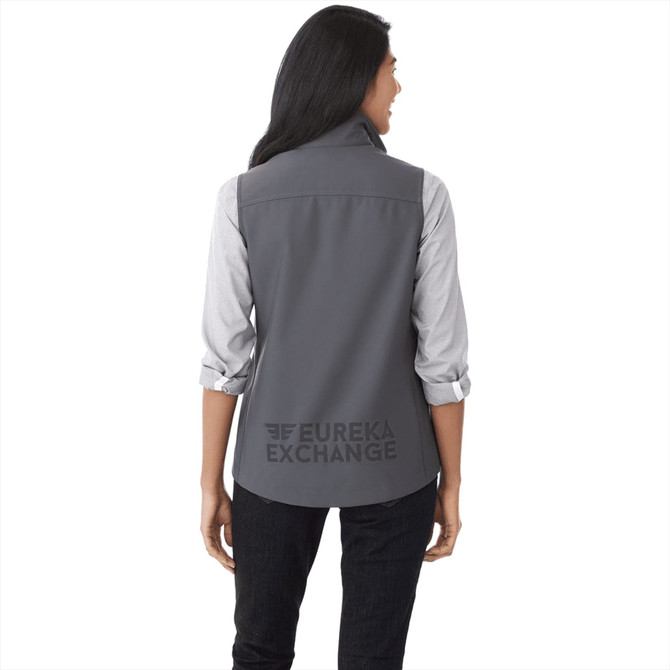 A grey women's softshell vest with a logo on the back, featuring a collared design and long sleeves underneath.