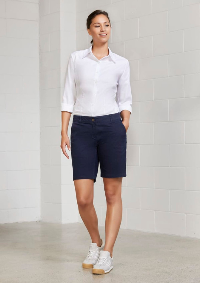 A pair of navy blue women's chino shorts displayed on a model, paired with a white shirt and casual shoes.