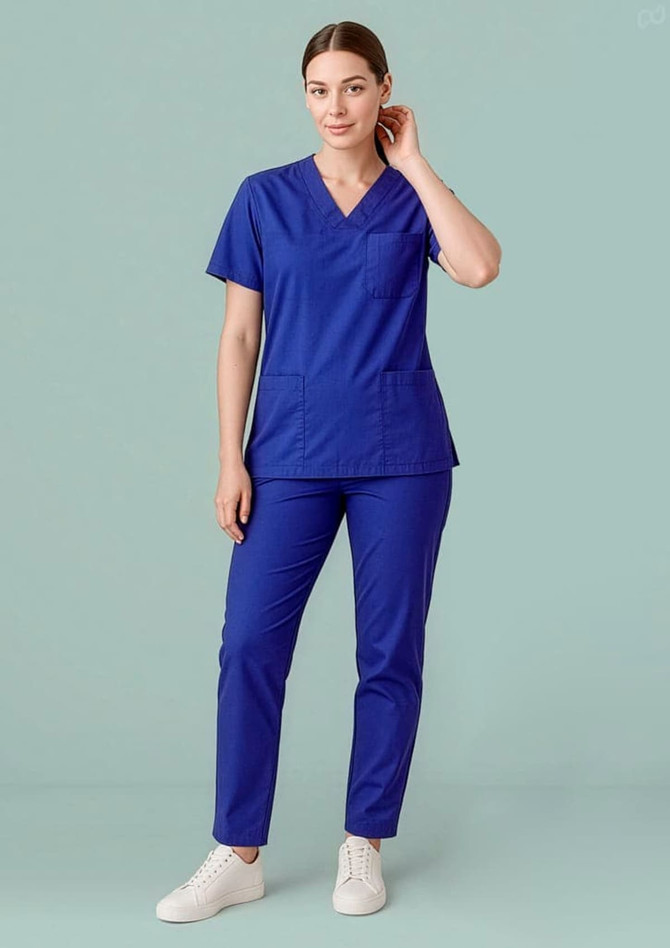 A unisex scrub top in royal blue, paired with matching pants, featuring a pocket and branding.