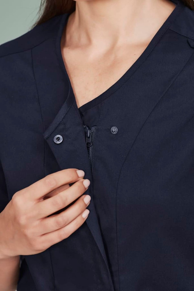A navy zip-front scrub top featuring a crossover design, with buttons and a smooth fabric finish.
