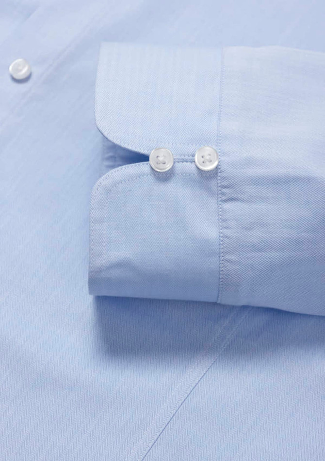 A light blue women's luxe long sleeve button-up shirt featuring a double cuff design and buttons.