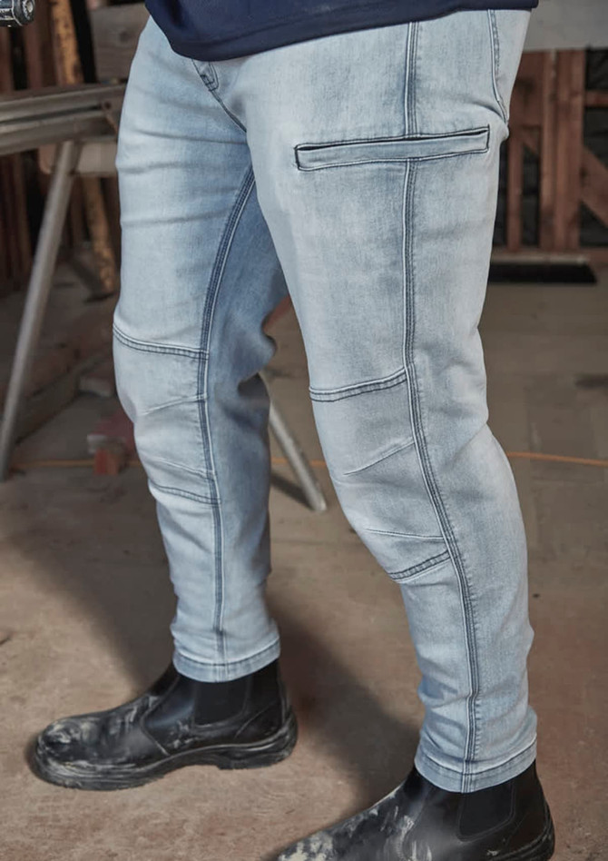 A pair of light blue stretch jeans with cargo-style pockets, worn with black work boots.