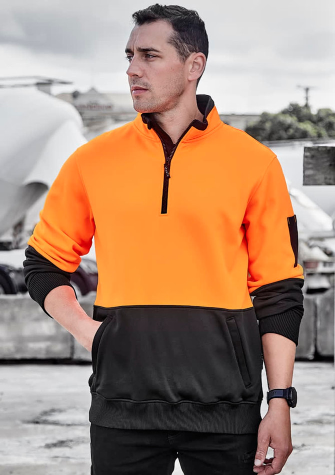 A unisex pullover in bright orange and black, featuring a half zip and a pocket, with a logo on the sleeve.